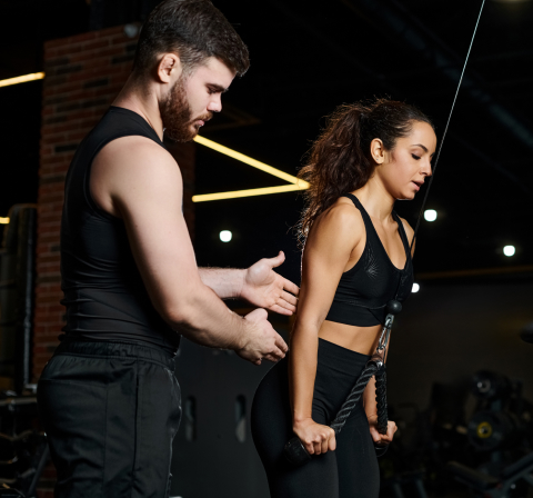 Trainer helping client with dumbbells